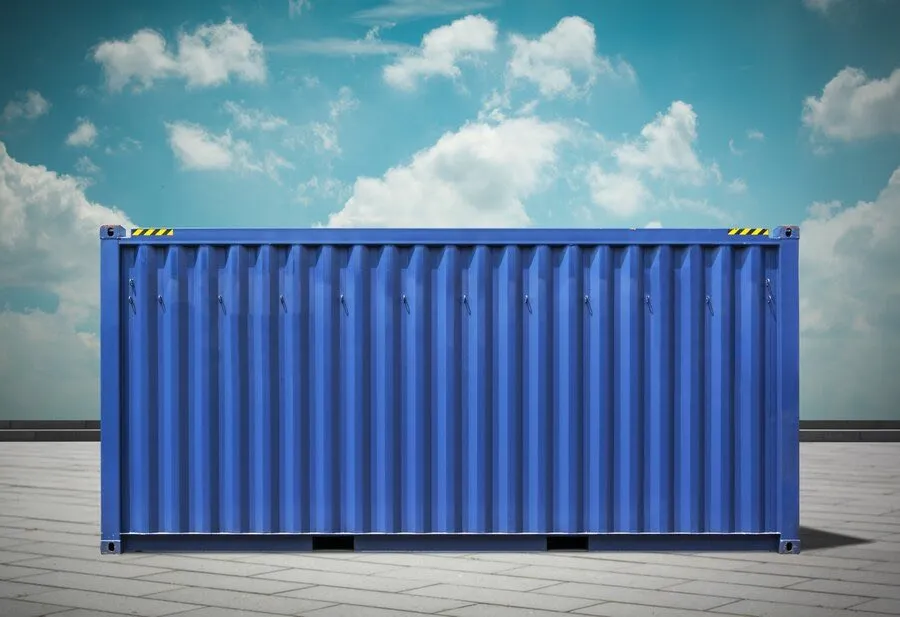 A blue shipping container standing on a paved yard