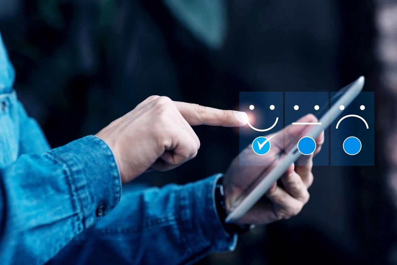 A finger selecting a smiling face on a tablet showing customer satisfaction ratings