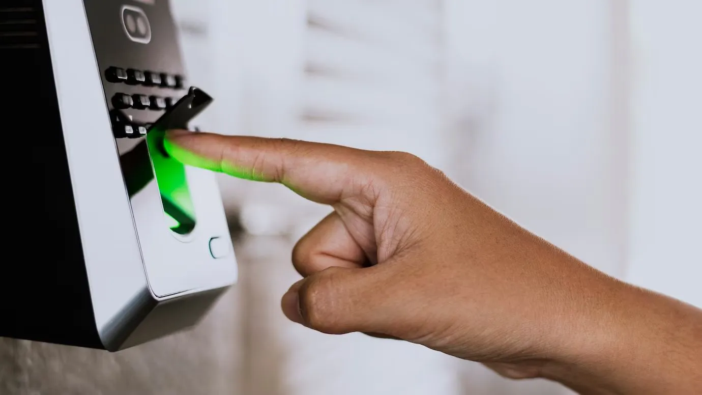 A finger pressed against a fingerprint access control reader