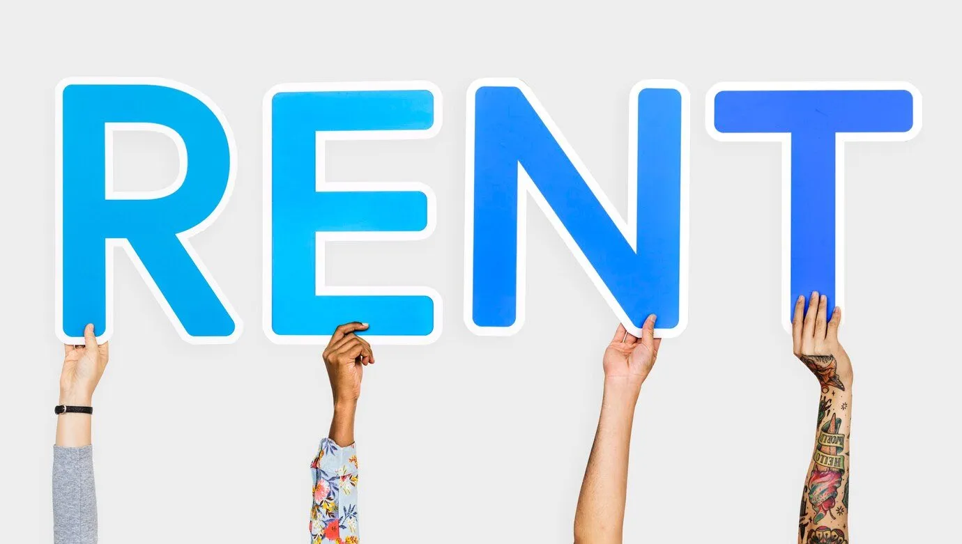 Four hands holding up cut-out letters spelling the word rent