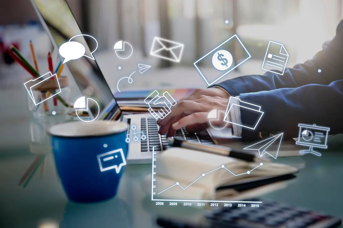 Hands typing on a laptop surrounded by illustrated marketing, analytics and messaging icons