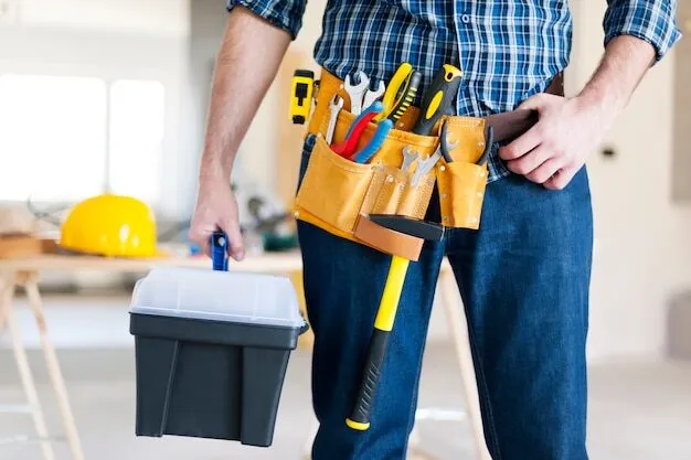 A maintenance worker carrying a toolbox and wearing a tool belt