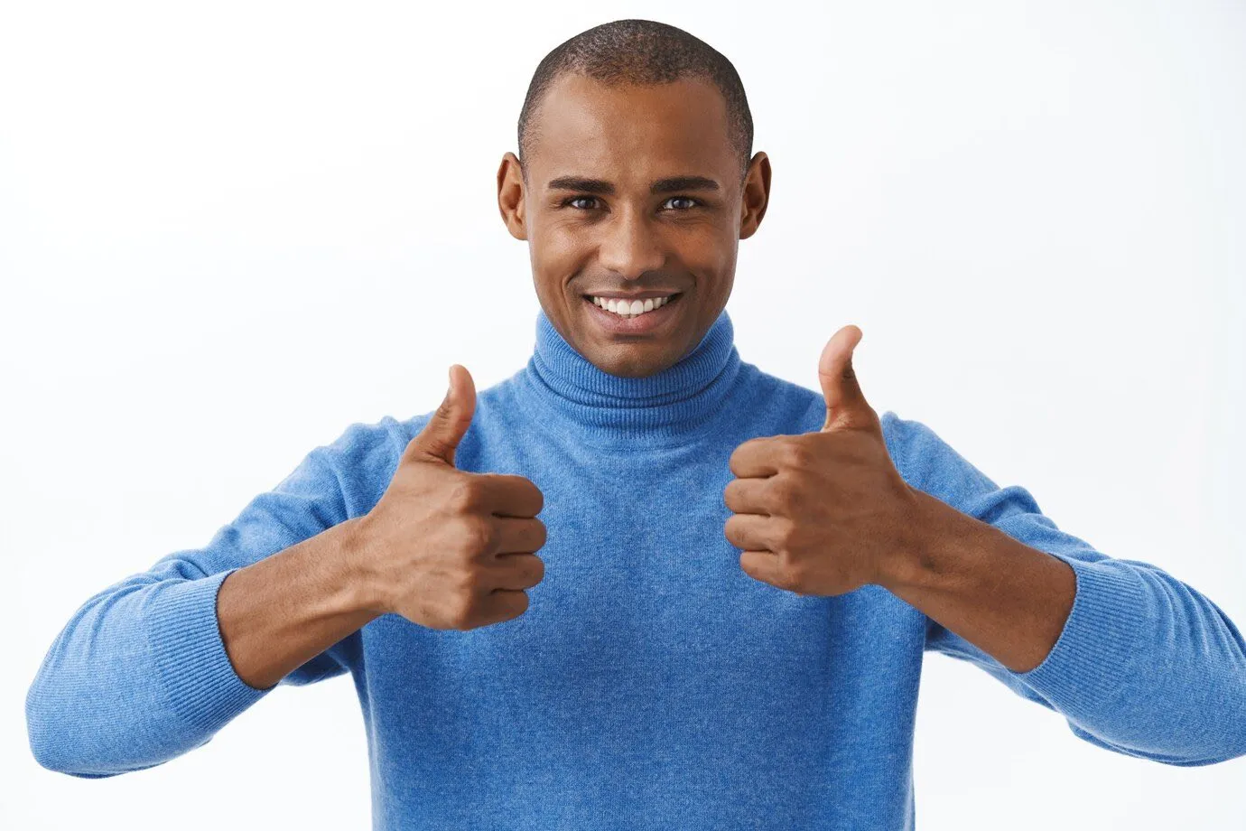 A man in a blue jumper giving two thumbs up
