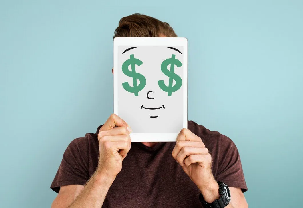 A person holding a tablet displaying a face with dollar signs for eyes