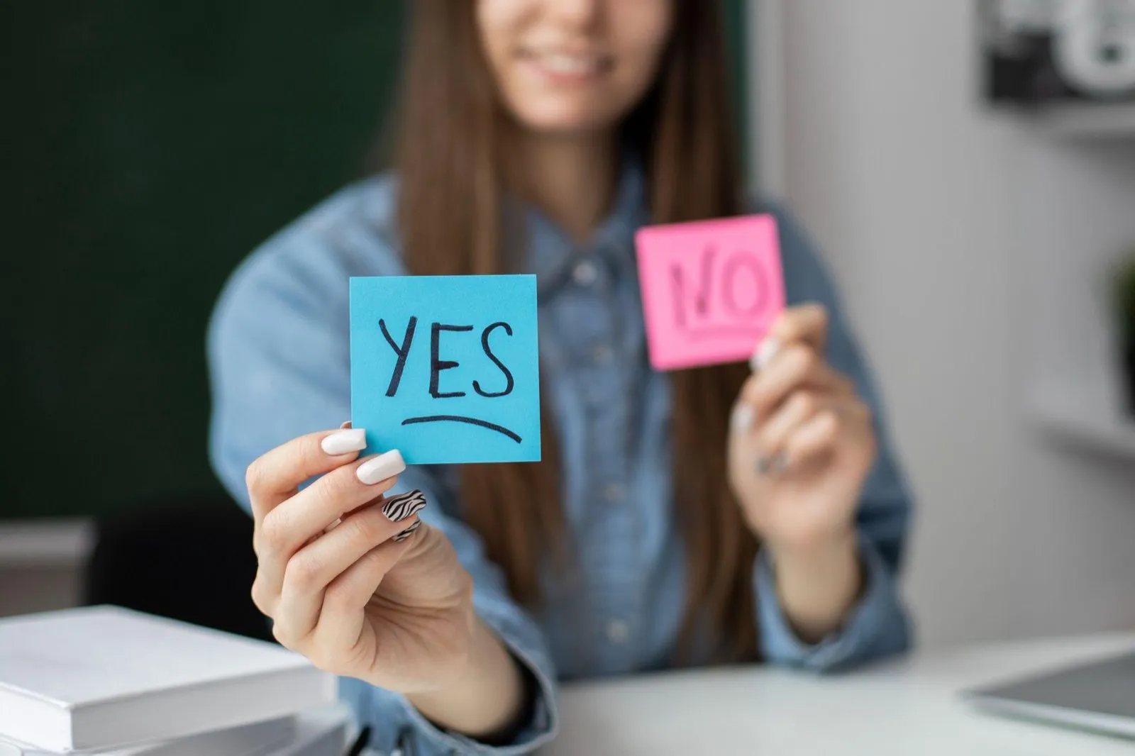 A person holding up sticky notes reading Yes and No