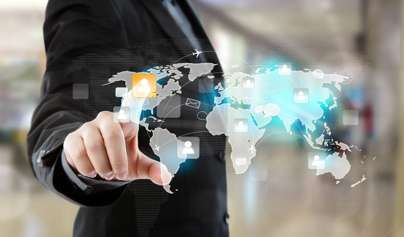 A person in a suit touching a world map overlaid with user icons and connecting routes