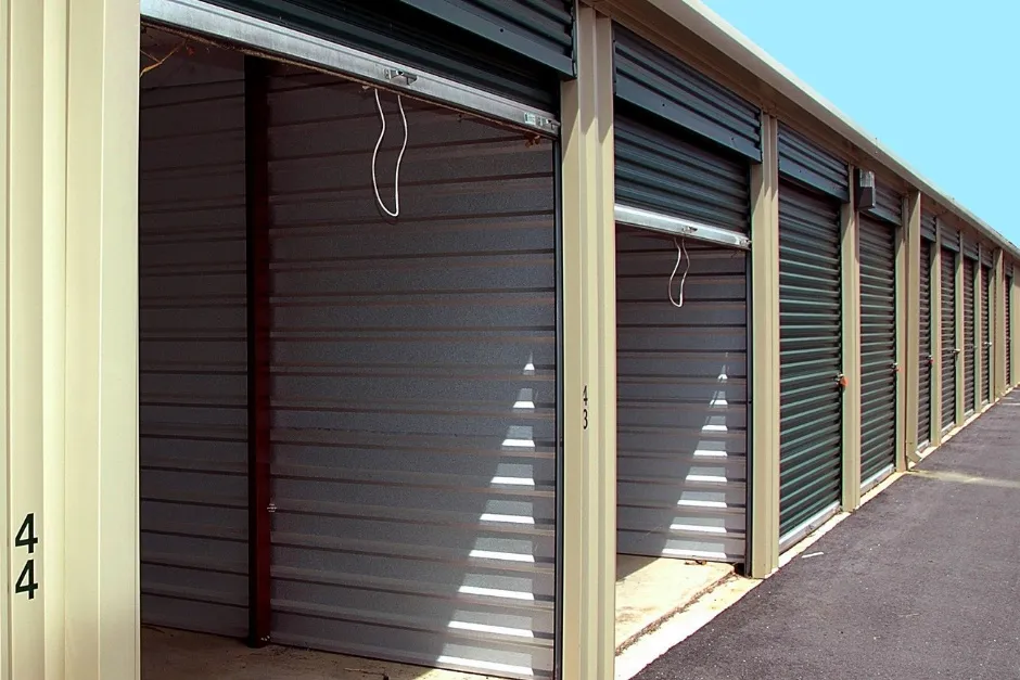 A row of self storage units with roller shutter doors at an outdoor facility