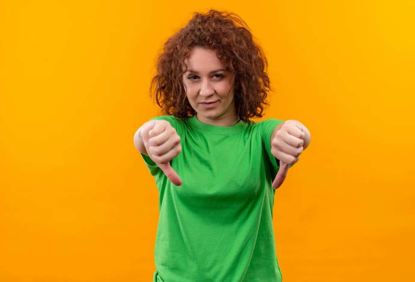 A woman in a green t-shirt giving two thumbs down