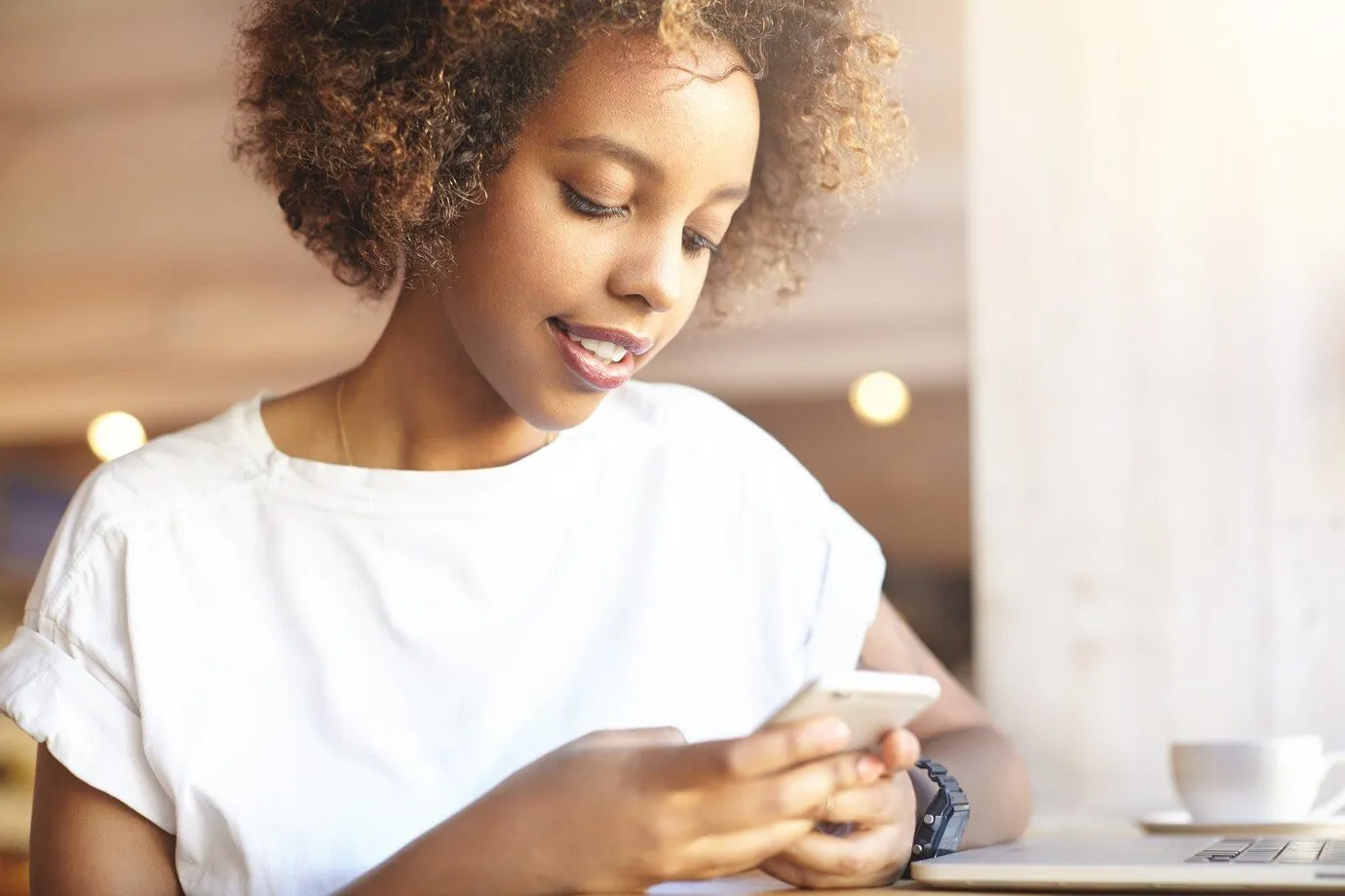 A woman using her smartphone at a cafe table